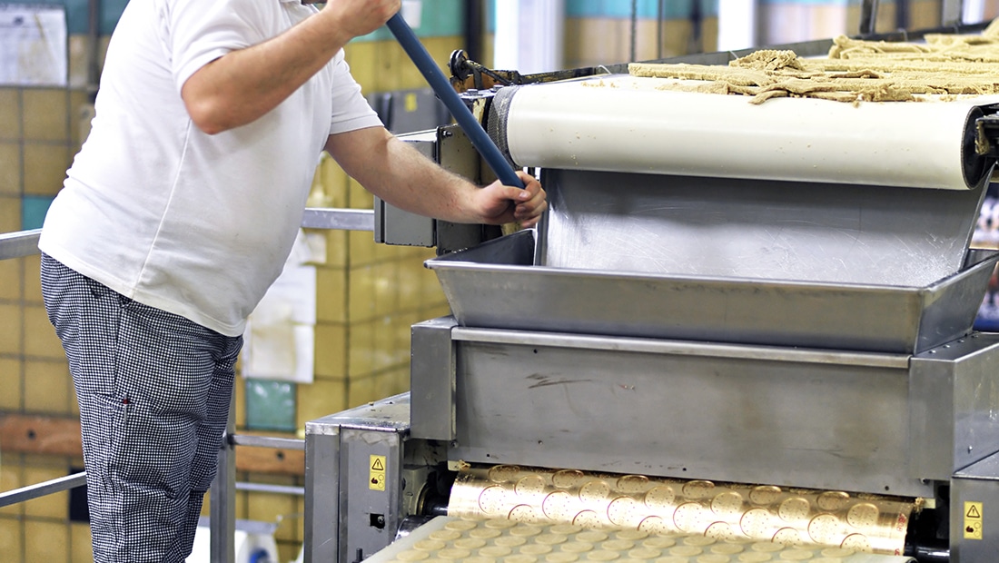 A sanitation worker cleans a bread machine at the Pan-O-Gold production site in St. Cloud, MN.